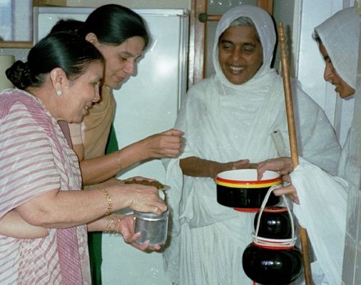 Lay women give alms to nuns