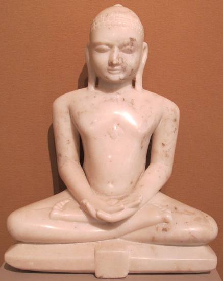 This 18th-century statue of a Jina from the Deccan has no emblem – lāñchana – to identify him. The emblem is usually on the central panel of his pedestal. With characteristics such as closed eyes, nudity and a very plain style, this figure is Digambara.