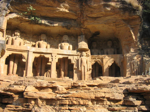 Colossal Jinas cut into the cliff. These 15th-century Digambara statues may have been designed to survive the world's end. Their nakedness offended Emperor Babur, who ordered them to be destroyed. But they were only mutilated and some later repaired.