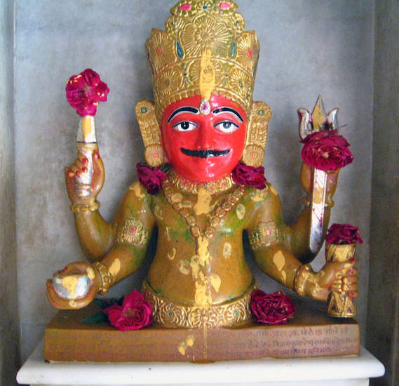 Replica image of Nākoḍā Bhairava in Prakrit Bharati Academy in Jaipur, Rajasthan. This figure is decorated with flower offerings. Nākoḍā Bhairava is a very popular protective god in the Śvetāmbara Pārśvanātha temple in Nākoḍā, Rajasthan.