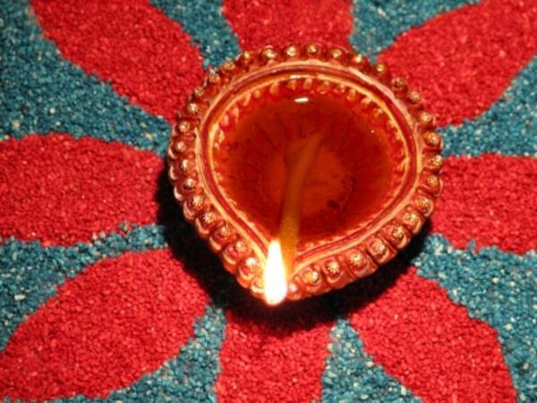 A traditional oil lamp forms part of a rangoli during Dīvālī. Rangoli – auspicious patterns and pictures – are a favourite activity during Indian festivals and events such as weddings. Symbolising welcome and auspiciousness, these designs are traditionall