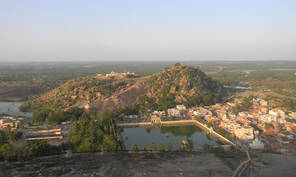View from Vindhya-giri over Lake Kalyani towards Candra-giri. The town of Shravana Belgola is built on the plain between these hills and has several temples, including a mutt. The pilgrimage sites, including the statue of Bāhubali, are on the hilltops.