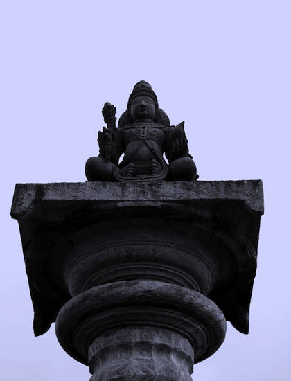 Image of the Jain deity Brahmadeva at the top of a Brahmadeva-stambha. These tall columns are common outside Digambara temples in southern India. Found in Karkala in Karnatak, this example faces the colossus of Bāhubali within the temple courtyard.
