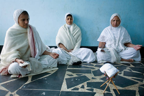 Śvetāmbara nuns meditate in front of a cloth-wrapped bookstand, used to hold scriptures. To Jains, meditation helps purify the soul of karma and is thus vital for spiritual progress. It is a daily obligatory duty – āvaśyaka – for mendicants.