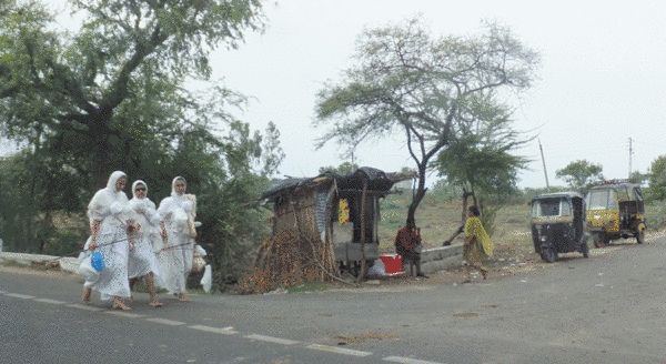 A common sight in India, nuns in pairs or small groups walk along the road. Jain mendicants undertake the wandering life – vihāra – which means walking miles most days to find accommodation and alms. They carry monastic equipment in bundles and bags.