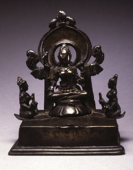 Eleventh-century bronze maṇḍala of Padmāvatī. Sitting on a lotus throne with a nimbus behind her, the goddess is flanked by attendants, underlining her status and power. Padmāvatī is particularly popular in Karnataka and southern India.