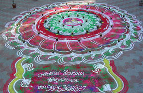 A large rangoli with oil lamps ready to be lit for Dīvālī – the 'Festival of Lights'. A rangoli is a pattern on the ground symbolising welcome and auspiciousness, and may be quite simple or, as here, colourful and quite intricate. Traditionally made of co