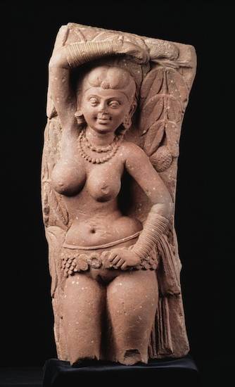 A sandstone yakṣī or yakṣiṇī from Mathurā. From the second century, the statue is Vrikshaka, a guardian goddess. Yakṣas and yakṣīs were probably originally nature deities that protected auspicious trees and rural shrines
